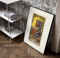 Crowned queen holding pentacle on throne poster in a black frame leaning beside a shelf in a raw-plaster loft