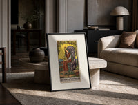 Crowned queen holding pentacle on throne print in a black frame leaning on a travertine table in a sunlit lounge
