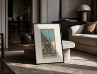 Queen of Swords tarot card print in a black frame leaning on a travertine table in a sunlit lounge