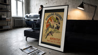Woman dancing with white cat print in a slim black frame leaning on a dark sofa in a concrete print studio