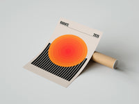 Gently curled Radiate 2026 Orange Sun print beside its protective shipping tube