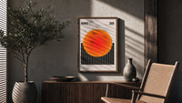 Radiate 2026 Orange Sun poster framed above a fluted sideboard beside a potted tree