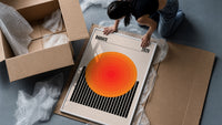 Radiate 2026 Orange Sun framed print being unpacked from protective bubble wrap and a box