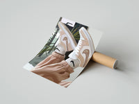 Gently curled Raised Legs in Beige Sneakers print beside its protective shipping tube