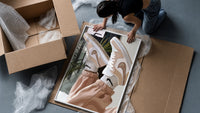 Raised Legs in Beige Sneakers framed print being unpacked from protective bubble wrap and a box