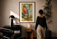 Bird A Merry Christmas to You print in a black frame on a sunlit plaster wall, a person looking on beside a mushroom lamp