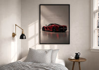 Red Ferrari LaFerrari print in a black frame above a bed with striped linens, a brass wall lamp and a sunlit window