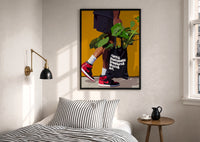 Plant Tote and Red High-Tops print in a black frame above a bed with striped linens, a brass wall lamp and a sunlit window
