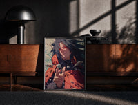 Black-framed Anime warrior with red eyes print on a moody console with designer coffee-table books