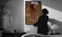 Red Platform Heels and Mesh Bag print in a slim black frame being hung on a sunlit wall in a monochrome room