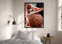 Red Sneakers on a Basketball print in a black frame above a bed with striped linens