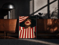 Black-framed Red Stripes and a Wide Hat print on the floor in front of a dark wooden console