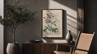 Pink rose botanical illustration poster framed above a fluted sideboard beside an olive tree