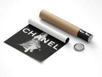 Rolled Chanel fashion print emerging from a capped cardboard tube on a light gray background