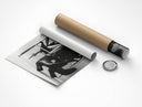 Rolled Let's Play a Little Game print partially unrolled beside cardboard shipping tube and cap on white background showing B&W boots detail
