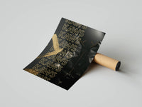 Rolled black KAWS figure print with repeating gold KAWS text on dark background beside a cardboard tube