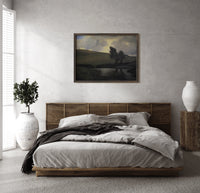 Windswept trees by a pond print in a dark wood frame above a rattan bed on a plaster wall