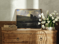 Windswept trees by a pond print in an oak frame on a farmhouse dresser beside white tulips