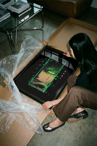 Hands unrolling a dark Zoro One Piece art print showing flowing hair on a concrete surface