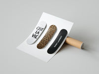 Woman unboxing a set of three decorated Saint Laurent skateboard decks with leopard print detailing