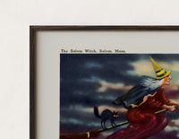 Close-up of the Witch flying on broomstick with cat print's dark wood frame corner and archival matte paper