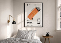 Salmon Lighter Seafood Market print in a black frame above a bed with striped linens, a brass wall lamp and a sunlit window