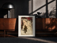 Black-framed Woman with flowing hair holding feather print on a moody console with designer coffee-table books