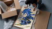 Samurai swordsman with blue lightning dragon framed print being unpacked from protective bubble wrap and a box