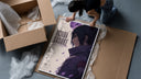 Anime male character profile portrait framed print being unpacked from protective bubble wrap and a box