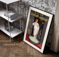 Woman bathing in soap suds poster in a black frame leaning beside a shelf in a raw-plaster loft