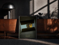Black-framed Se7en box scene print on a moody console with designer coffee-table books