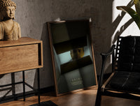 Se7en box scene print in a walnut frame leaning between a wood side cabinet and a black leather chair