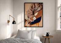 Black Woman in a Brown Crewneck print in a black frame above a bed with striped linens, a brass wall lamp and a sunlit window