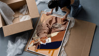 Black Woman in a Brown Crewneck framed print being unpacked from protective bubble wrap and a box