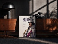 Black-framed Marine fleet admiral in white uniform print on a moody console with designer coffee-table books
