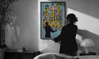Seven of Cups print in a slim black frame being hung on a sunlit wall in a monochrome room