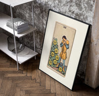 Man leaning on staff with pentacles poster in a black frame leaning beside a shelf in a raw-plaster loft