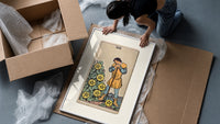 Man leaning on staff with pentacles framed print being unpacked from protective bubble wrap and a box