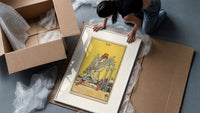 Man carrying five swords framed print being unpacked from protective bubble wrap and a box