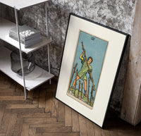 Man holding staff among wands poster in a black frame leaning beside a shelf in a raw-plaster loft