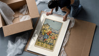 Two children exchanging cups of flowers framed print being unpacked from protective bubble wrap and a box