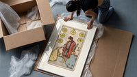 Merchant giving coins to beggars framed print being unpacked from protective bubble wrap and a box