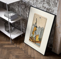 Ferryman poling boat with swords poster in a black frame leaning beside a shelf in a raw-plaster loft
