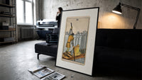 Ferryman poling boat with swords print in a slim black frame leaning on a dark sofa in a concrete print studio