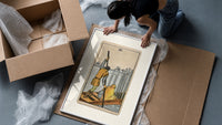 Ferryman poling boat with swords framed print being unpacked from protective bubble wrap and a box
