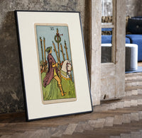 Rider on white horse with staff print in a black frame leaning beside a vintage door on parquet