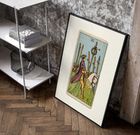 Rider on white horse with staff poster in a black frame leaning beside a shelf in a raw-plaster loft