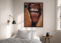 Smile with Multicolored Grillz print in a black frame above a bed with striped linens, a brass wall lamp and a sunlit window