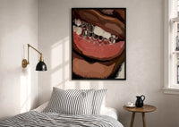 Smile with Silver Grillz print in a black frame above a bed with striped linens, a brass wall lamp and a sunlit window
