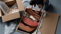 Smile with Silver Grillz framed print being unpacked from protective bubble wrap and a box